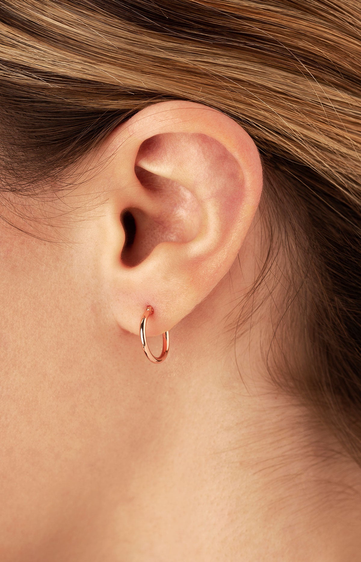Ben Garelick 14K rose gold 12mm small hoop earring worn on the earlobe