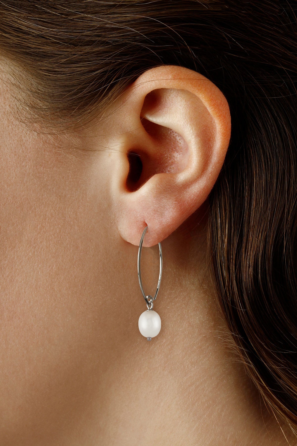 Sterling silver sweep pearl dangle earring shown on the ear