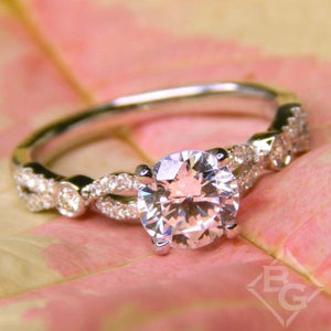 Kirk Kara White Gold "Lori" Vintage Style Twist Diamond Engagement Ring Angled Front View with Floral Background