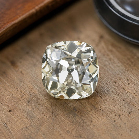 Old mine cut diamond on a jeweler's bench, showing the soft cushion outline and the open culet at the center of the stone