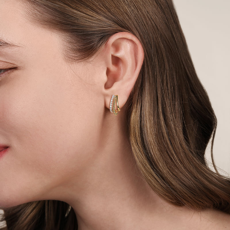 Model wearing Gabriel & Co. Bujukan two-tone diamond J hoop earrings with beaded gold and diamond rows