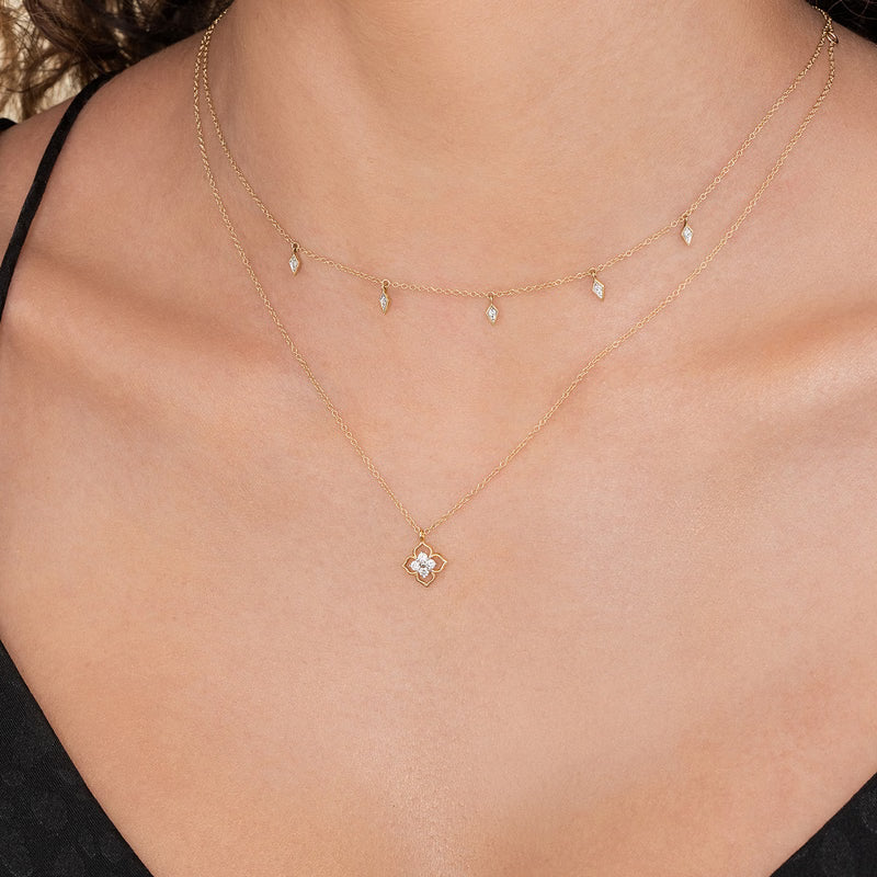 Gabriel & Co. NK6868 flower diamond pendant worn layered with a gold station necklace