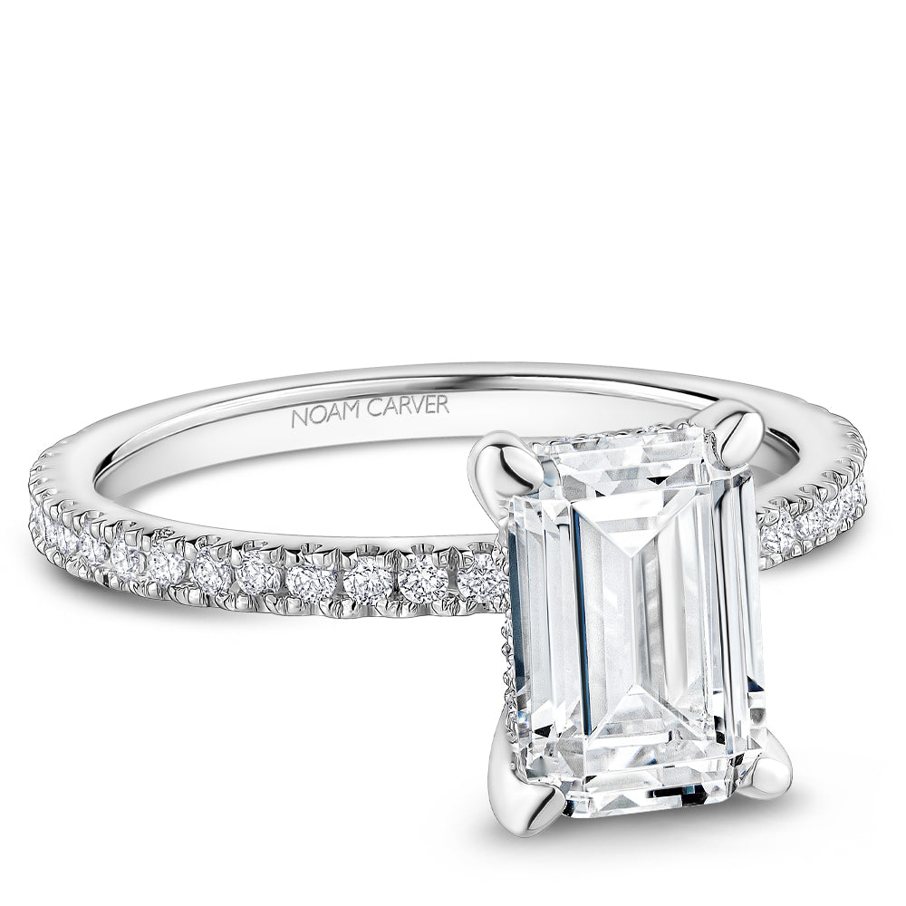 Noam Carver White Gold Prong Set Hidden Halo Emerald Cut Diamond Engagement Ring Featuring 0.30 Carats Total Weight Round Cut Shared Prong Set Diamonds.