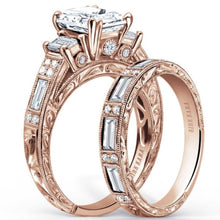 Load image into Gallery viewer, Kirk Kara Rose Gold &quot;Charlotte&quot; Emerald Cut Three Stone Diamond Engagement Ring Set Angled Side View
