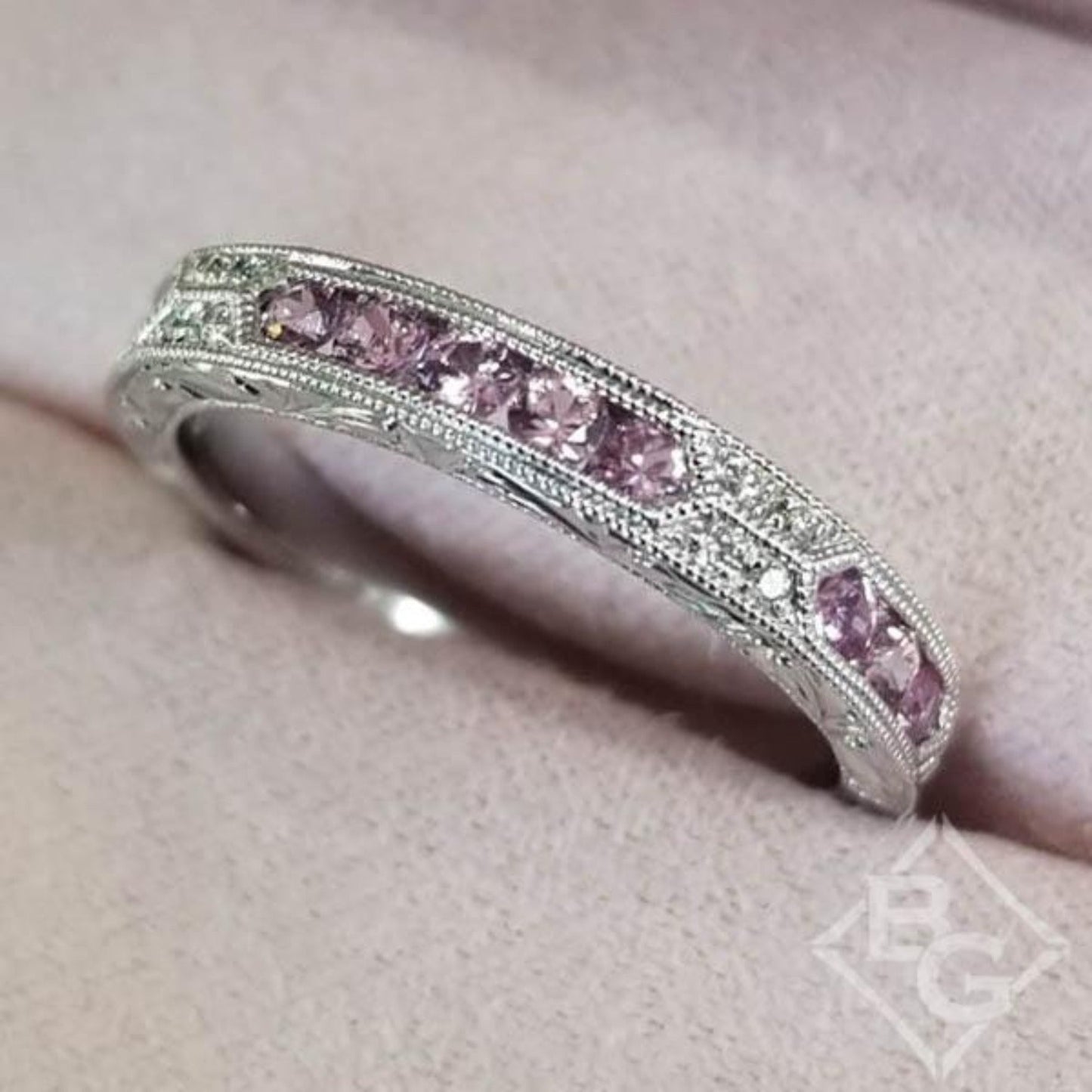 Kirk Kara White Gold "Charlotte" Pink Sapphire Round Cut Diamond Wedding Band Angled Top View In Box