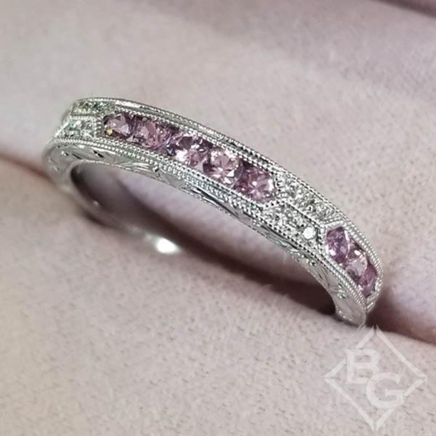 Kirk Kara White Gold "Charlotte" Pink Sapphire Round Cut Diamond Wedding Band Angled Top View In Box
