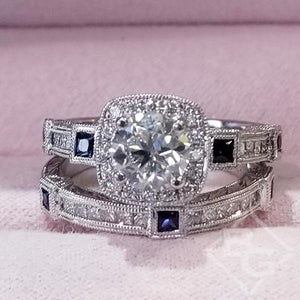 Kirk Kara White Gold "Carmella" Cushion Halo Baguette Station Blue Sapphire Diamond Engagement Ring Set On Box One on top of the other Close up