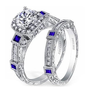Kirk Kara White Gold "Carmella" Cushion Halo Baguette Station Blue Sapphire Diamond Engagement Ring Set Angled Side View