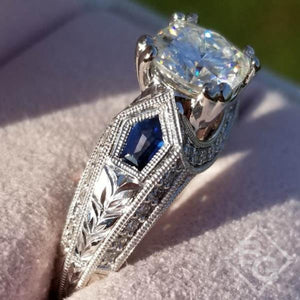 Kirk Kara White Gold "Charlotte" Kite Cut Blue Sapphire Diamond Engagement Ring Close Up Angled Side View In Box