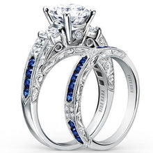 Load image into Gallery viewer, Kirk Kara White Gold &quot;Charlotte&quot; Three Stone Blue Sapphire Diamond Engagement Ring Set Angled Side View
